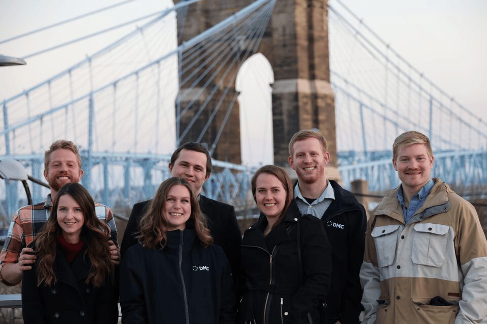 DMC's Cincinnati team poses for a photo outdoors.
